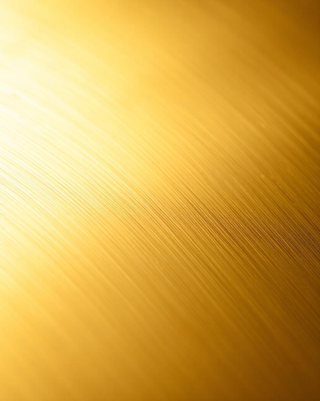 Macro detail of brushed brass surface grain under soft daylight